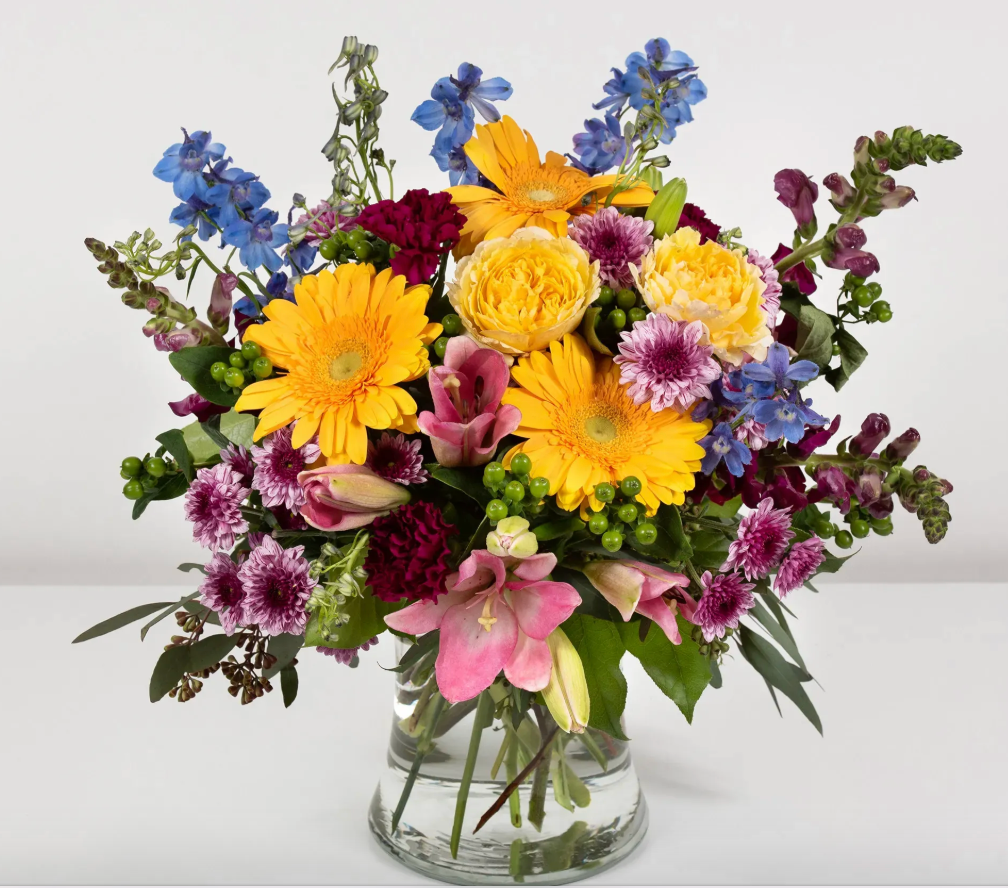 Colorful bouquet of flowers in a clear vase on a white background